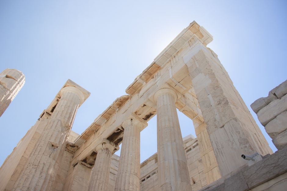 Stunning low angle shot of the ancient Parthenon columns in Athens, Greece, under a clear blue sky.